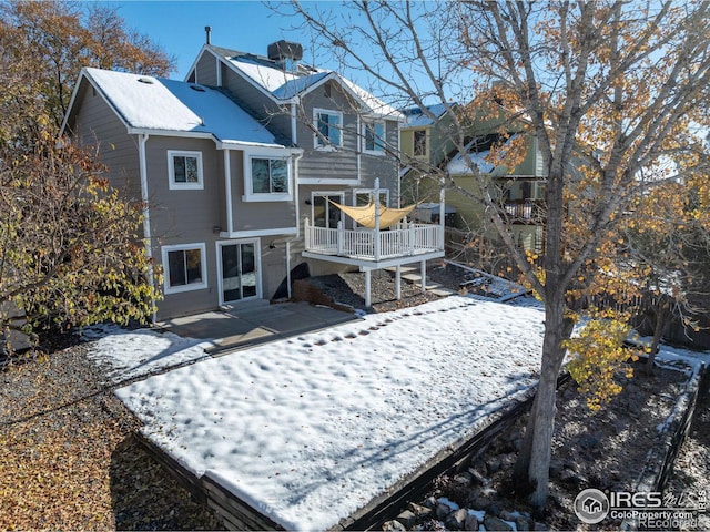 snow covered house with a patio area