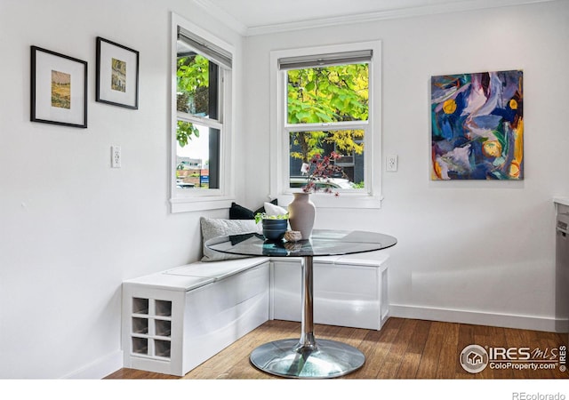 dining room featuring wood-type flooring, crown molding, and breakfast area