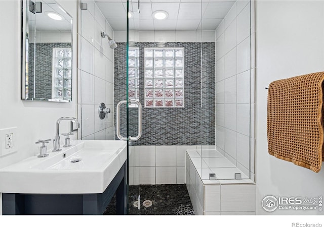 bathroom featuring sink and a shower with shower door