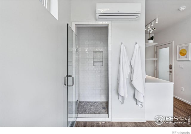 bathroom with a wall mounted air conditioner, wood-type flooring, and a shower with door