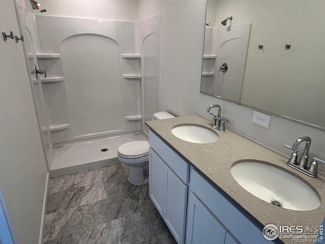 bathroom featuring walk in shower, vanity, and toilet