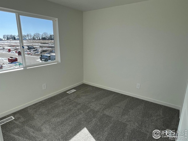 unfurnished room featuring dark carpet