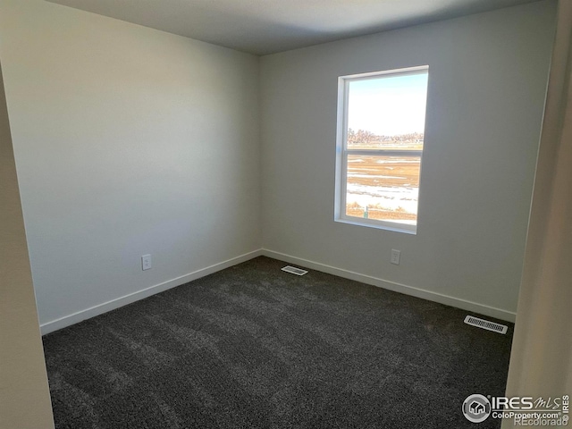 spare room with dark colored carpet