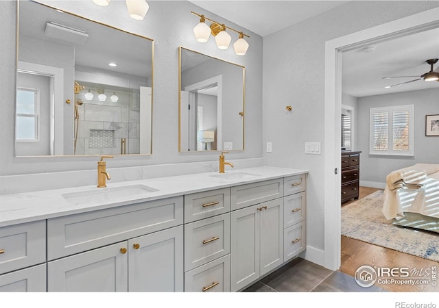 bathroom with ceiling fan, vanity, a shower with shower door, and hardwood / wood-style floors