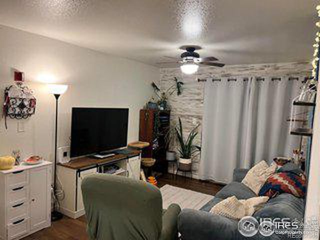 living room with ceiling fan, dark hardwood / wood-style flooring, and a textured ceiling