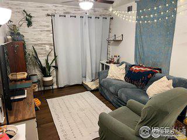 living room featuring dark wood-type flooring and ceiling fan