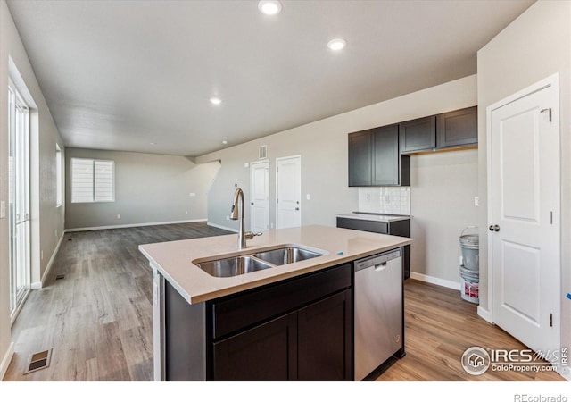 kitchen featuring sink, dark brown cabinets, a center island with sink, light wood-type flooring, and dishwasher