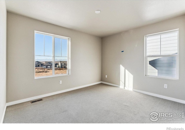 unfurnished room featuring a healthy amount of sunlight and carpet