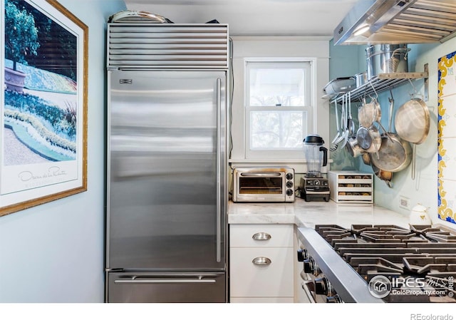 kitchen with high end appliances and white cabinetry