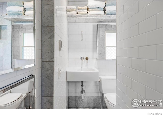 bathroom with tile walls and toilet