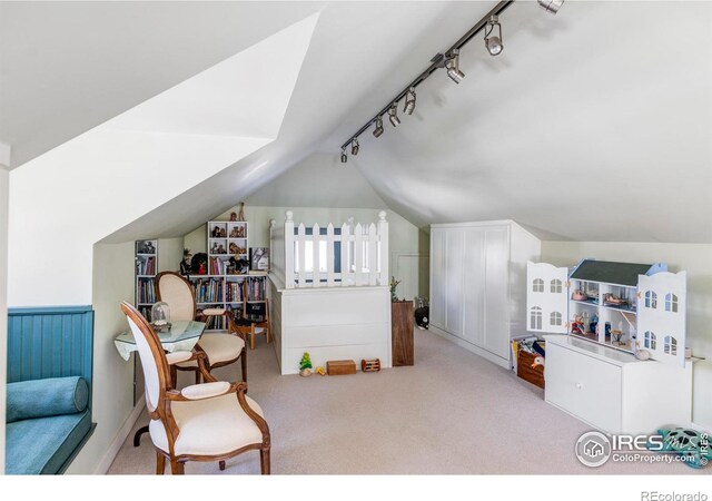 living area featuring lofted ceiling, light colored carpet, and track lighting