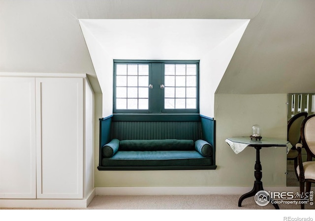 living area with lofted ceiling and light carpet