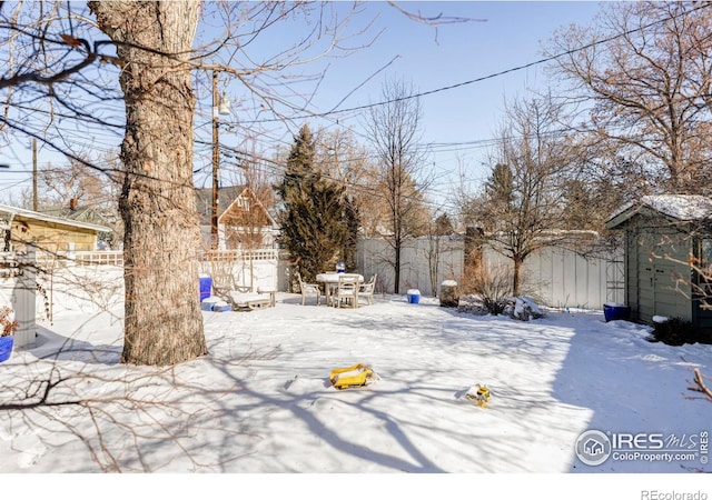 yard covered in snow featuring a storage unit