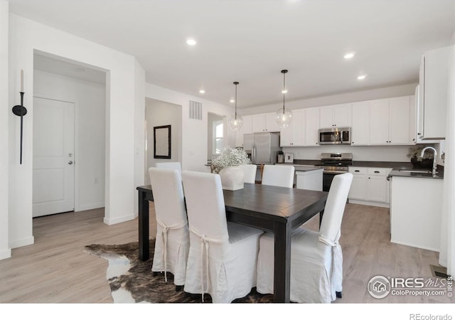 dining room with sink and light hardwood / wood-style floors