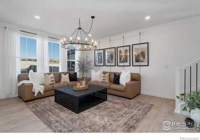 living room with a chandelier and light wood-type flooring