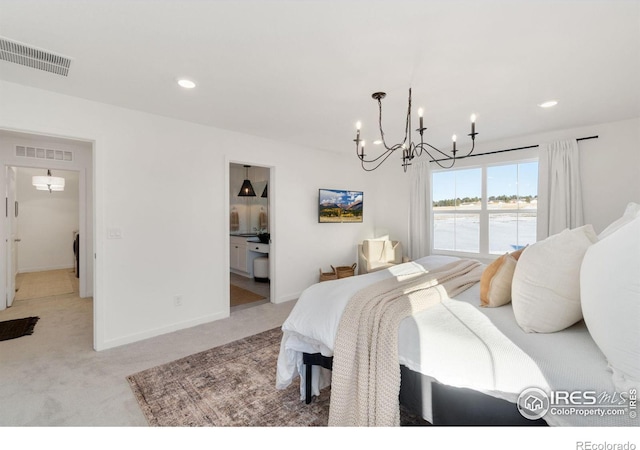 carpeted bedroom featuring ensuite bathroom and a chandelier