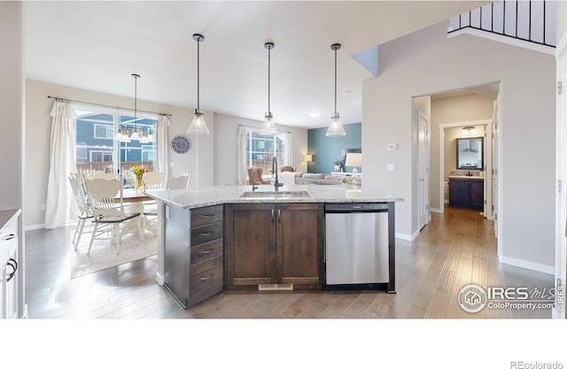 kitchen with dark brown cabinetry, dishwasher, light stone counters, hanging light fixtures, and a sink