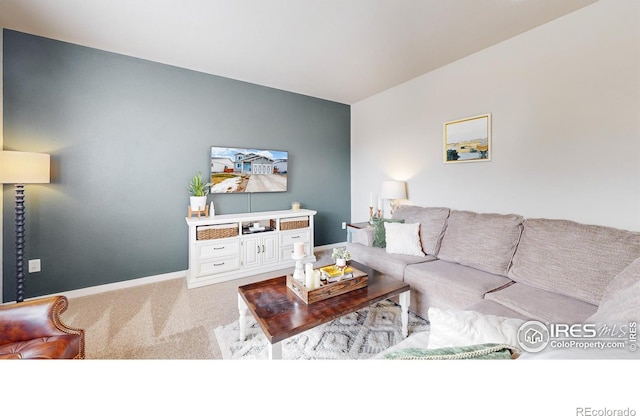 living room with lofted ceiling, carpet floors, and baseboards