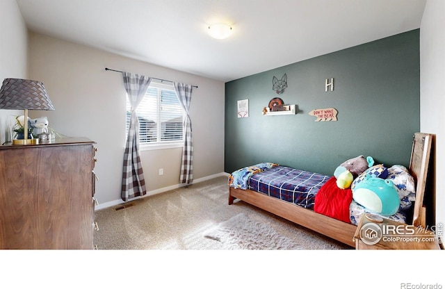 carpeted bedroom featuring visible vents and baseboards