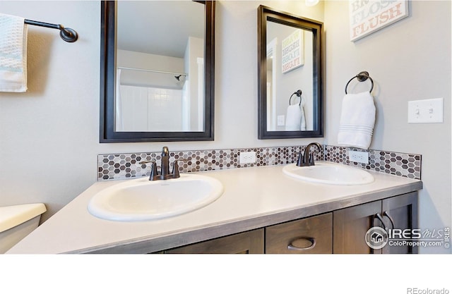 bathroom featuring a sink, toilet, and double vanity