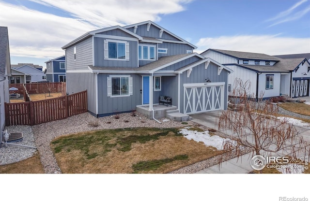 view of front of house featuring driveway, a shingled roof, a garage, and fence