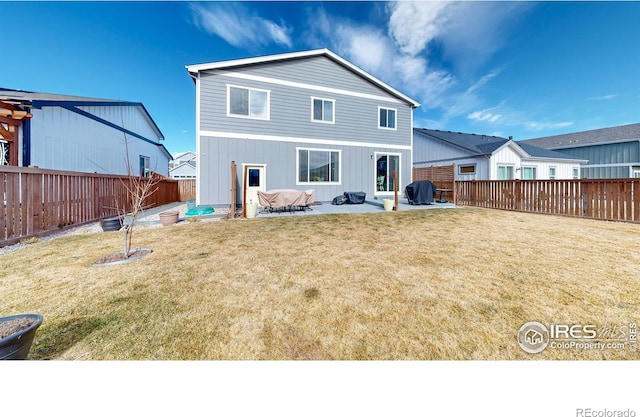 rear view of property with a patio, a lawn, and a fenced backyard