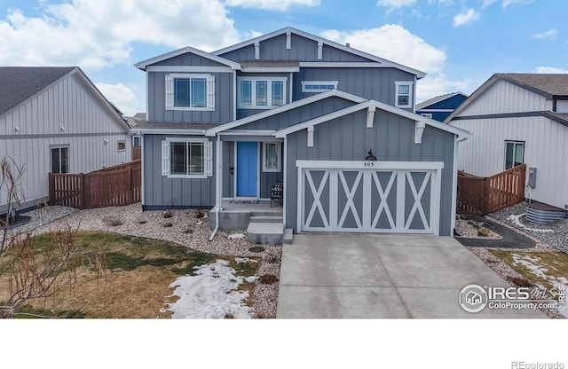 view of front of house featuring board and batten siding, driveway, a shingled roof, and fence