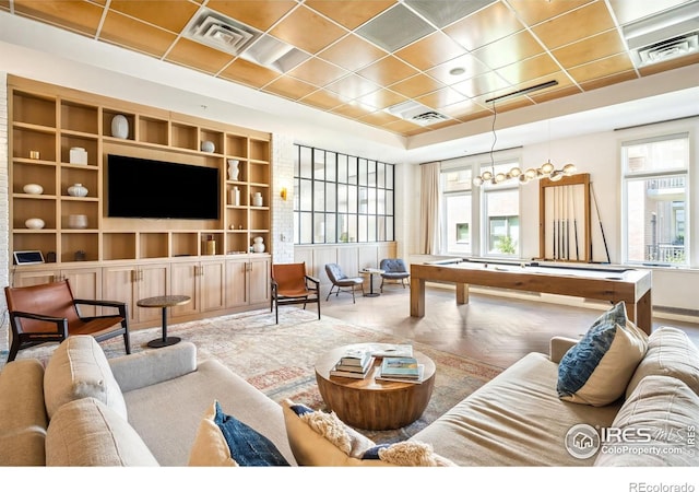 living room with parquet flooring, pool table, and built in features