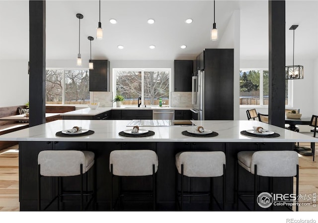 kitchen featuring appliances with stainless steel finishes, sink, pendant lighting, and a center island