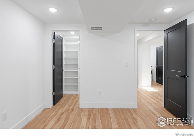 unfurnished room featuring light hardwood / wood-style flooring, a spacious closet, and a closet