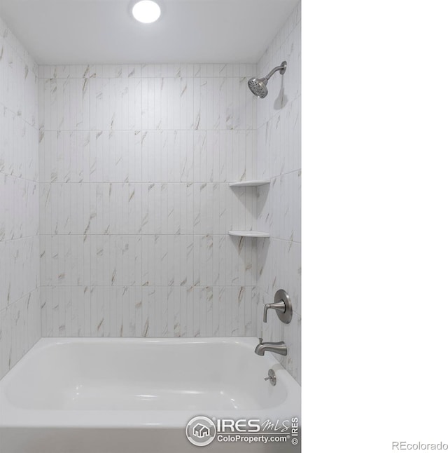 bathroom featuring tiled shower / bath