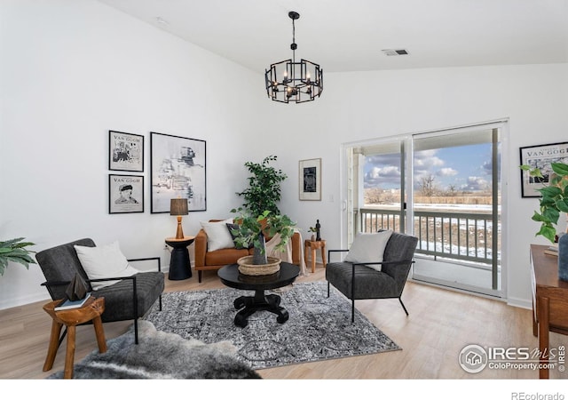 sitting room with hardwood / wood-style flooring and a chandelier