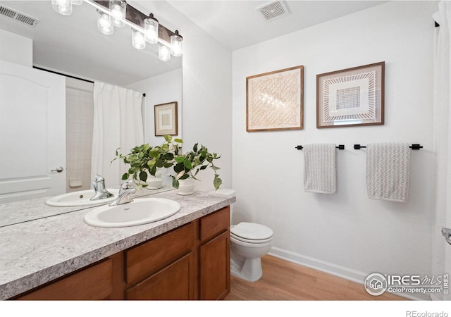 bathroom with a shower with shower curtain, vanity, toilet, and hardwood / wood-style floors