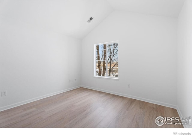 spare room with high vaulted ceiling and light hardwood / wood-style floors