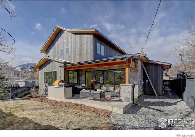 back of property with area for grilling, a mountain view, and a patio