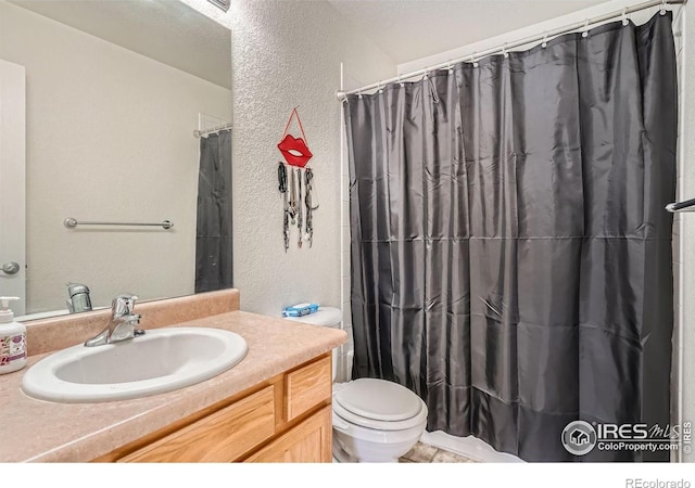 bathroom with vanity, toilet, and curtained shower