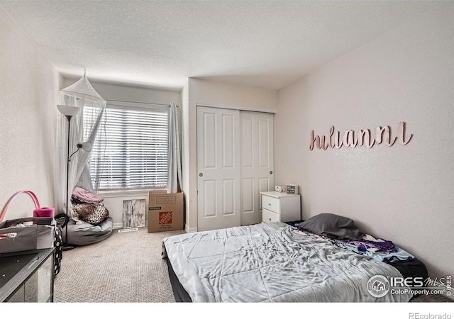 carpeted bedroom with a closet and a textured ceiling