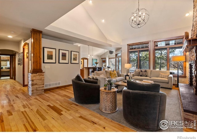 living room featuring high vaulted ceiling, light hardwood / wood-style flooring, and a notable chandelier