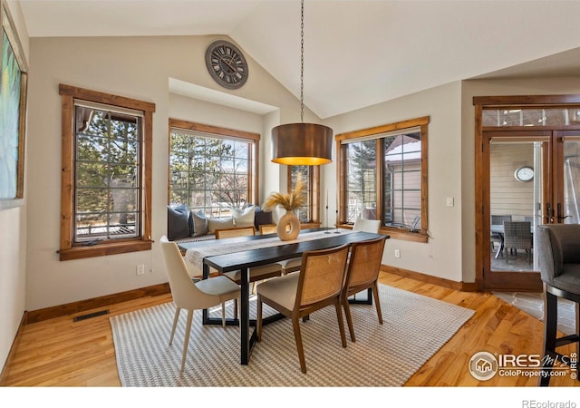 dining room featuring lofted ceiling and light hardwood / wood-style flooring