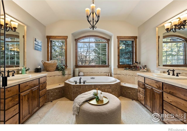 bathroom featuring an inviting chandelier, vanity, a wealth of natural light, and lofted ceiling