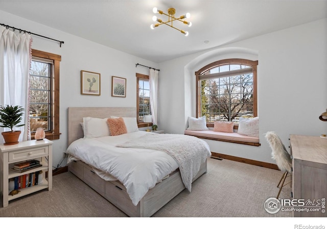 bedroom featuring multiple windows and a notable chandelier