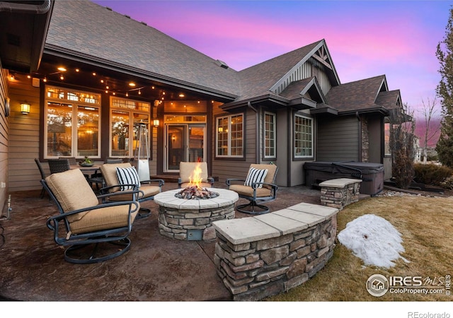 patio terrace at dusk with a hot tub and a fire pit