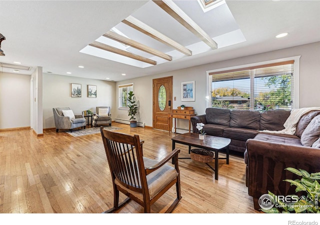 living room featuring light hardwood / wood-style flooring, a baseboard heating unit, and a skylight