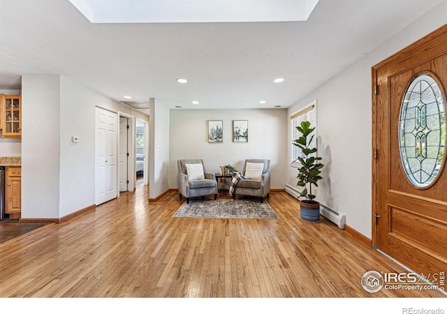 entrance foyer with a baseboard radiator, beverage cooler, and light hardwood / wood-style flooring