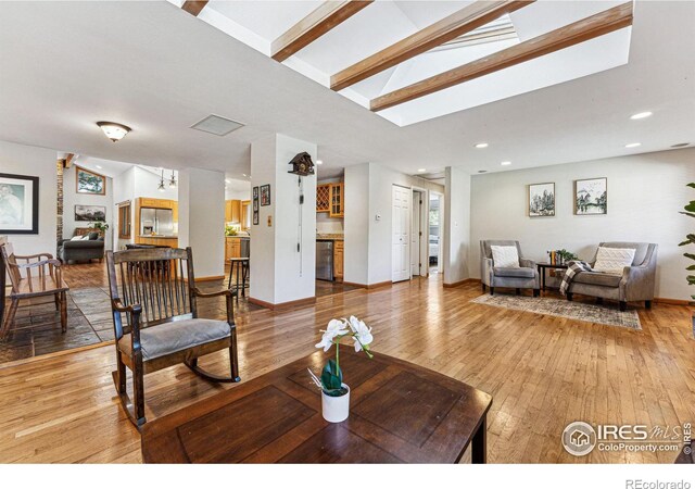 living room with lofted ceiling with beams and hardwood / wood-style floors