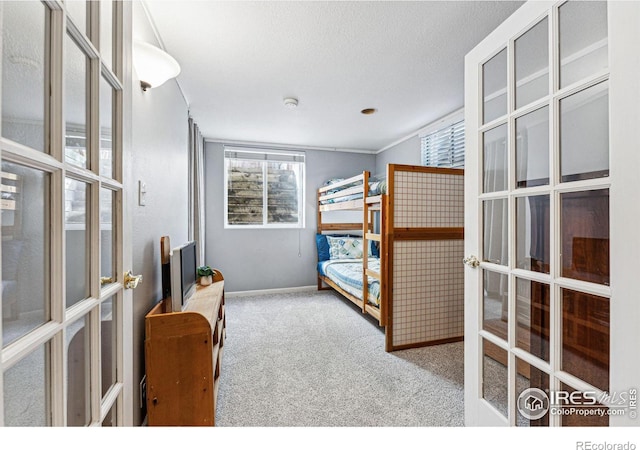 carpeted bedroom featuring a textured ceiling and french doors