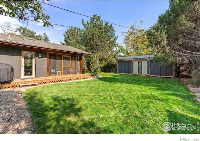 view of yard with a storage shed and a sunroom