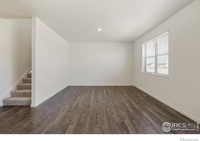 unfurnished room with dark hardwood / wood-style flooring