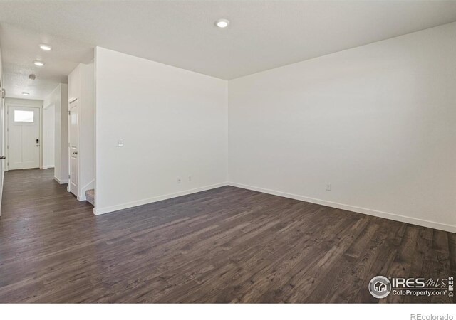 unfurnished room featuring dark wood-type flooring