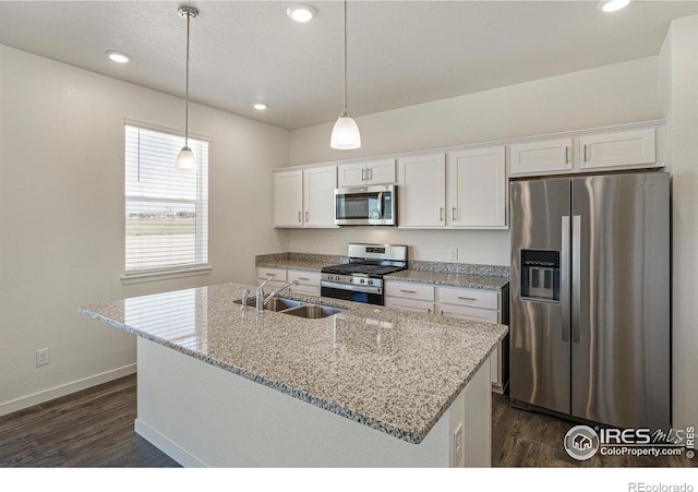 kitchen with hanging light fixtures, appliances with stainless steel finishes, sink, and white cabinets